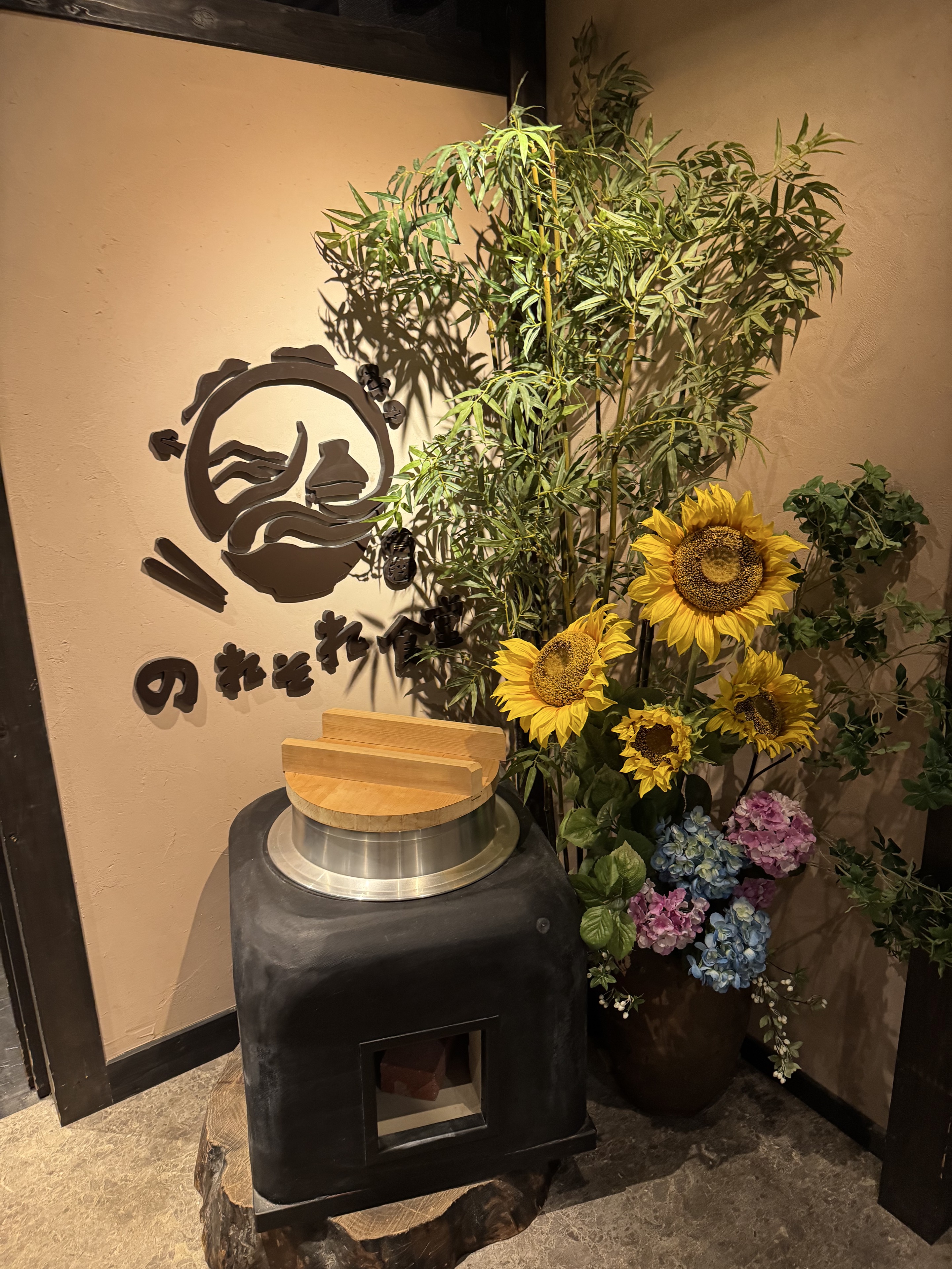 ひまわりと釜が飾られた、のれそれ食堂の入口