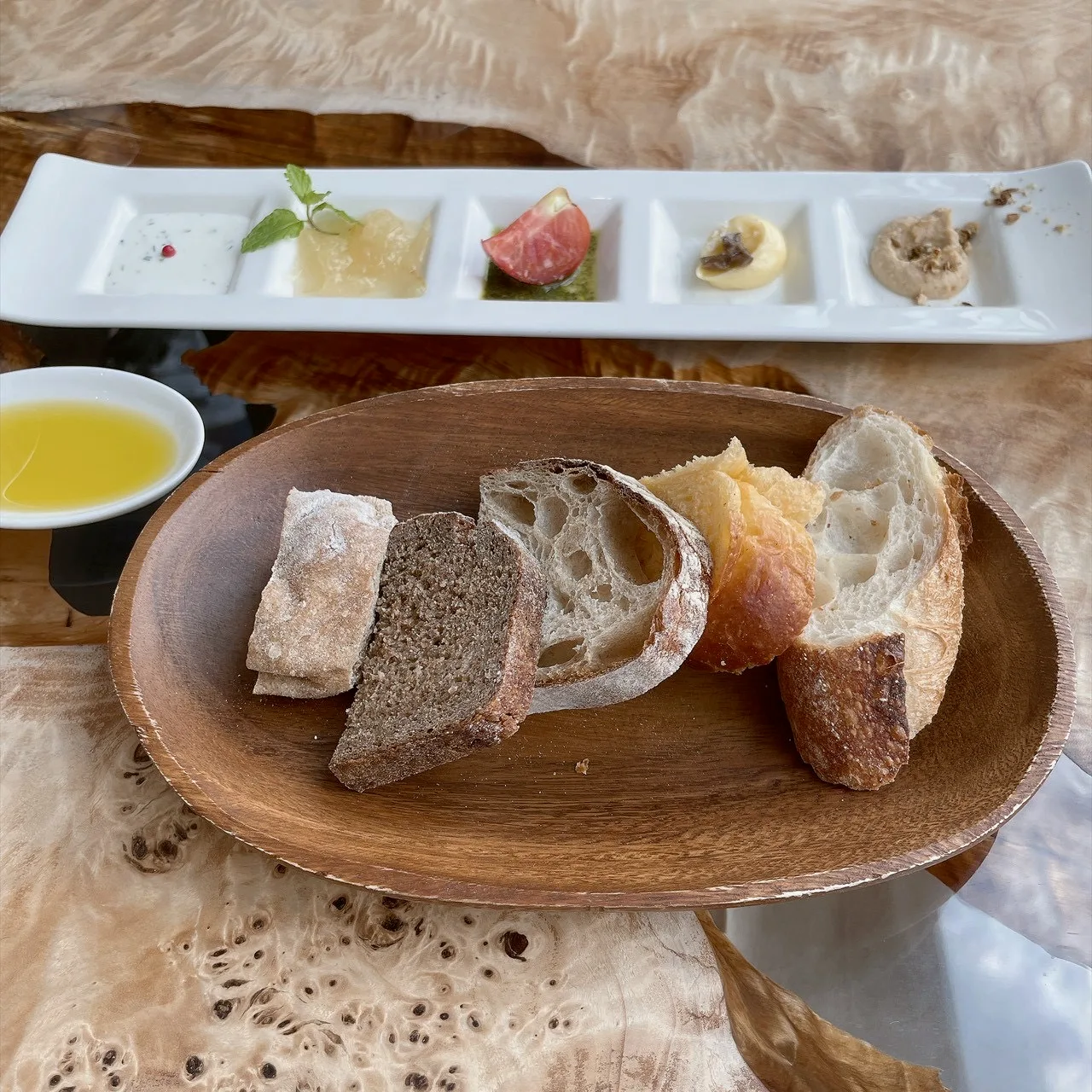 木の皿に盛った5種類のパンと料理に合わせるスプレッド