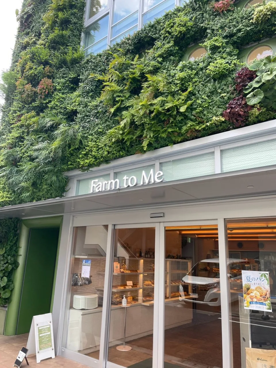 植物で覆われたFarm to Meの建物と1階ベーカリーの入口