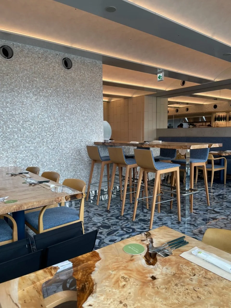 木目のテーブルと窓側の席が並ぶFarm to Me Restaurantの店内