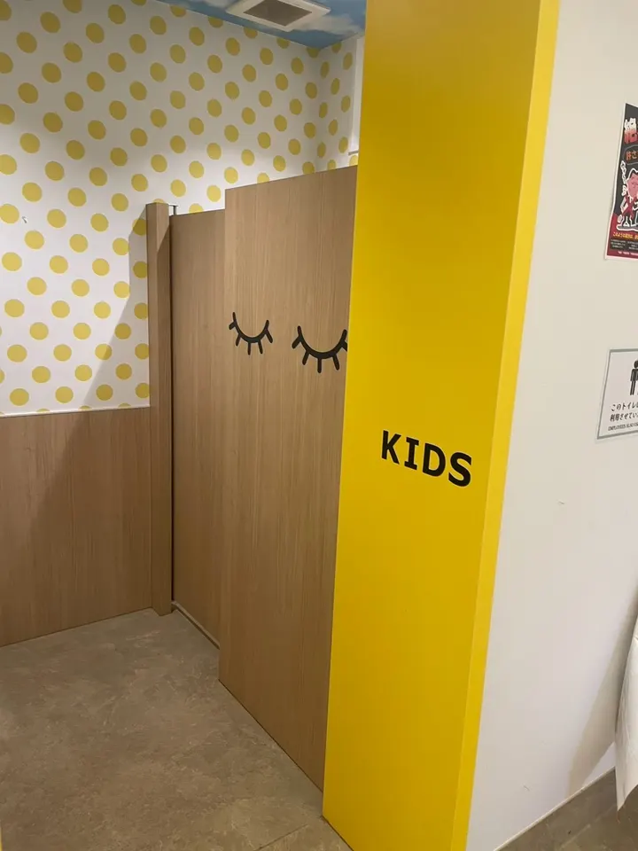 黄色い壁に「KIDS」と書かれた子ども用トイレの入口