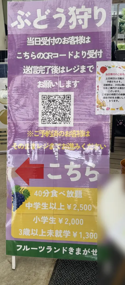 フルーツランドきまがせの当日受付の看板。QRコードと40分食べ放題の料金が書かれている