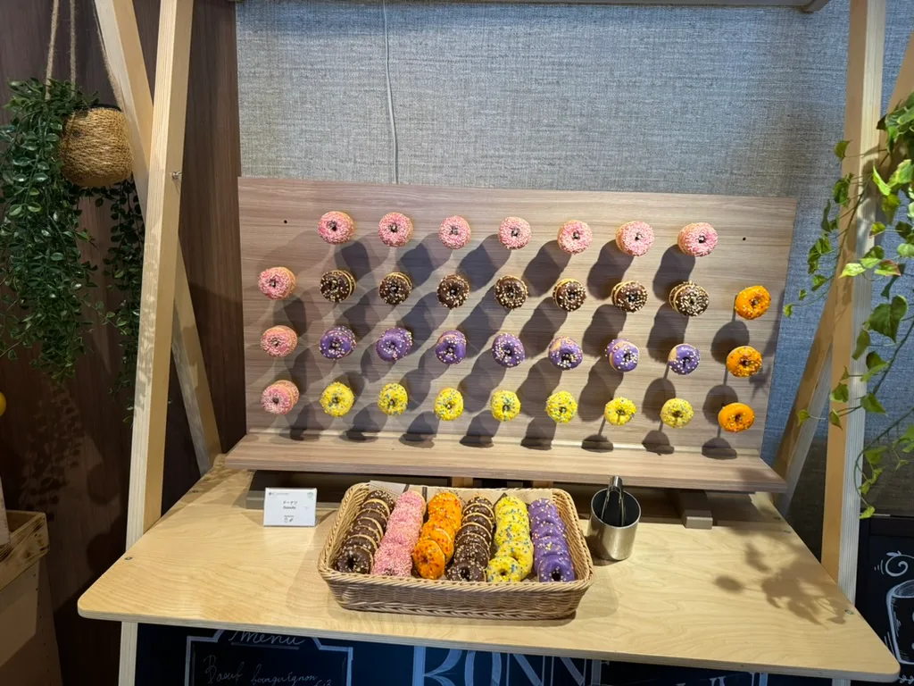 ピンク、紫、黄色など色とりどりのドーナツが壁一面に並ぶデザートコーナー