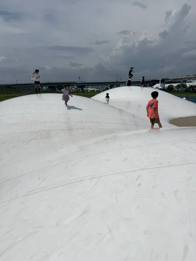 雲のような形の遊具の上で遊ぶ子どもたち
